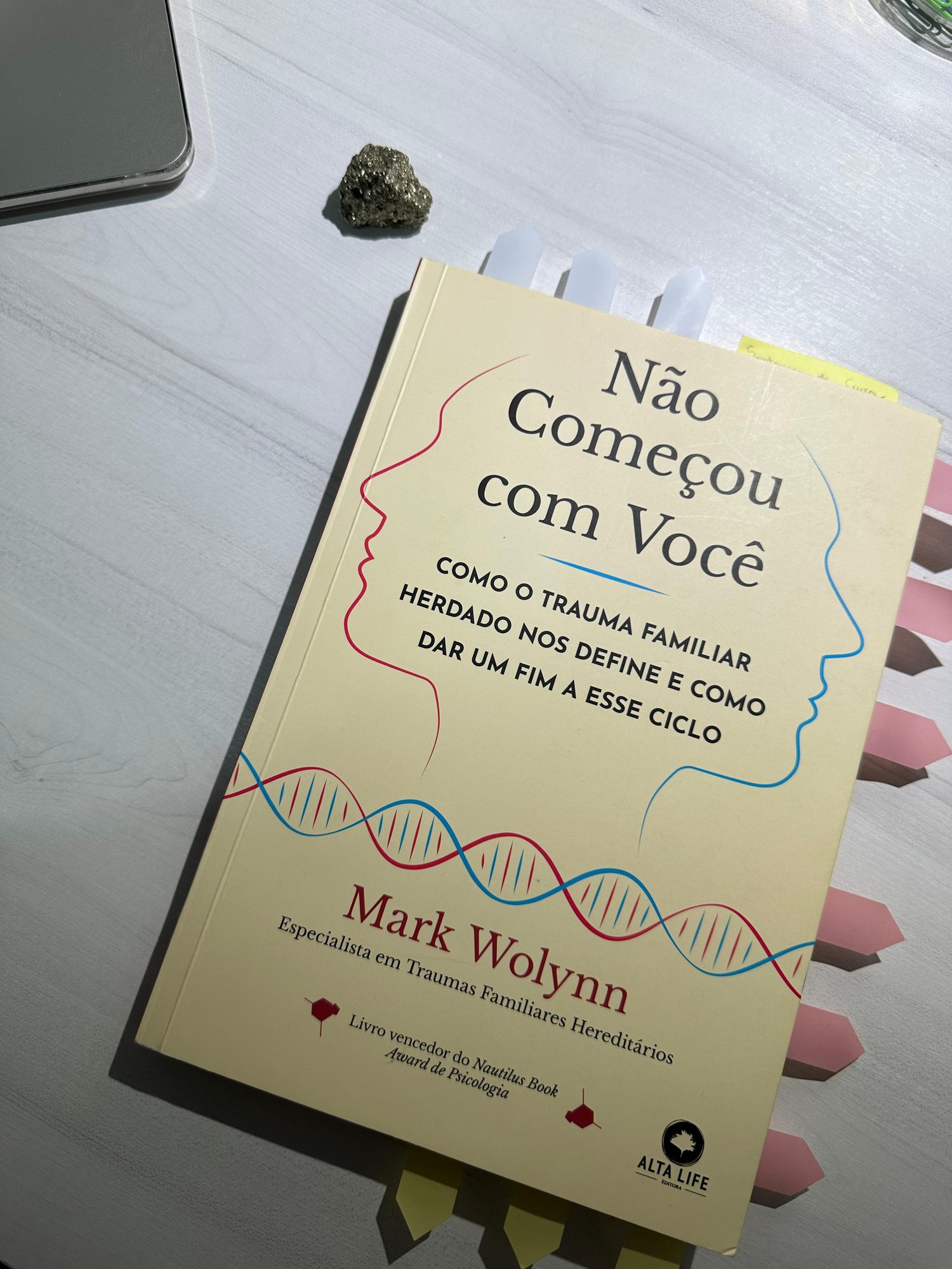 O livro Não Começou com Você sobre a mesa, ao lado de um cristal